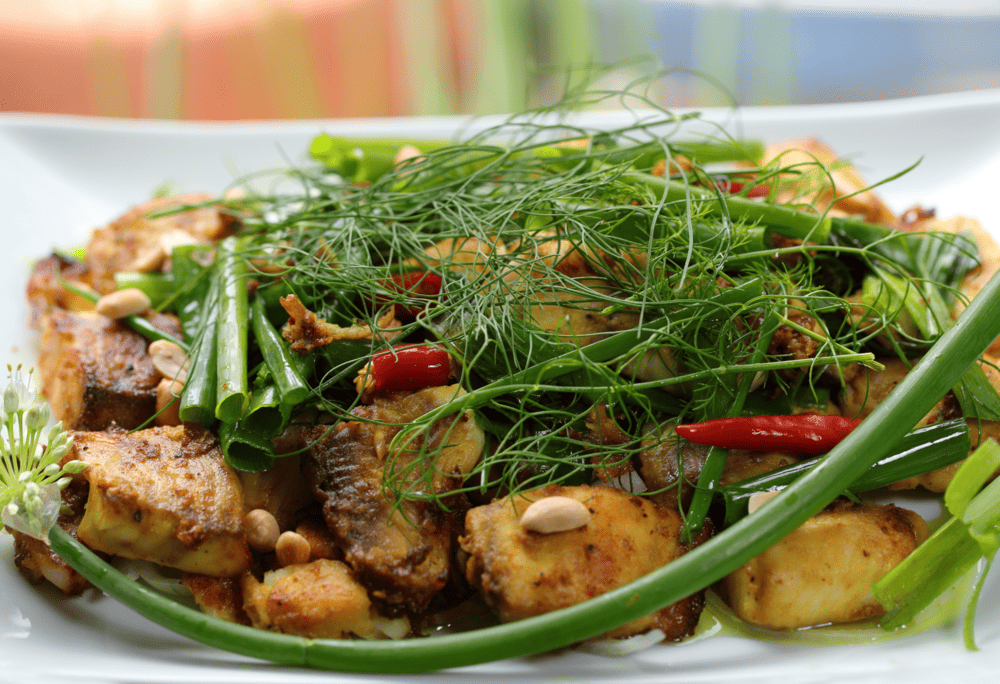 Cha Ca La Vong serves up Hanoi&rsquo;s iconic turmeric fish dish in a sizzling, herb-filled skillet (Source: Canva)